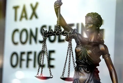 A small statue of Lady Justice in the window of a tax consulting office.